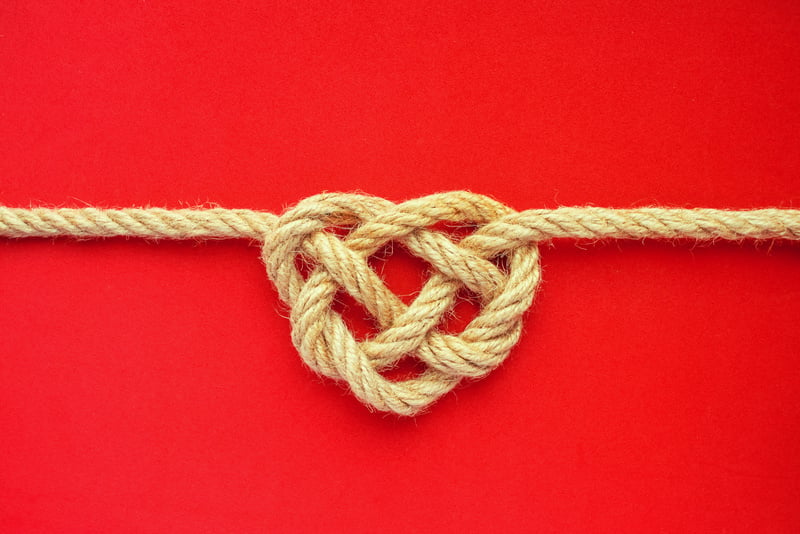 Heart Shape Rope Knot on Red Background. Jute Rope Celtic Knot.