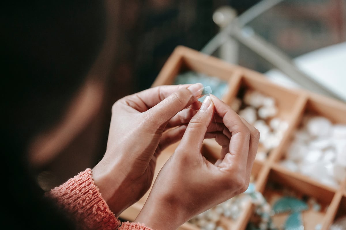 Anonymous woman stringing beads while making bracelet